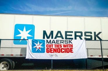 A banner from the "Mask off Maersk" campaign in front of a Maersk container. (Photo: Palestinian Youth Movement)