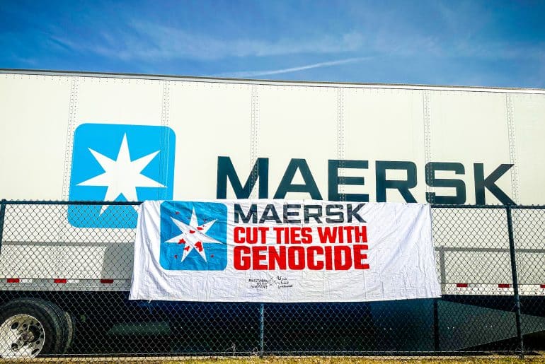 A banner from the "Mask off Maersk" campaign in front of a Maersk container. (Photo: Palestinian Youth Movement)