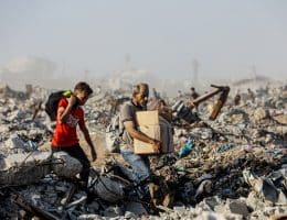Palestinians carry food parcels distributed by Gaza Humanitarian Foundation, June 16, 2025. (Photo: Omar Ashtawy/APA Images)
