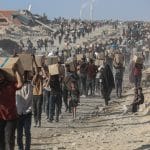 Palestinians carry food parcels distributed by Gaza Humanitarian Foundation, June 16, 2025. (Photo: Omar Ashtawy/APA Images)