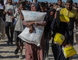 Palestinians bring back aid from distribution center near the Zikim border crossing, August 4, 2025. (Photo: Omar Ashtawy/APA Images)