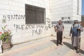 Palestinians inspect a burned-out mosque in the village of Aqraba, south of Nablus in the West Bank, after Israeli settlers set fire to the entrance and spray-painted Hebrew graffiti on the walls. (Photo: Mohammed Nasser/APA Images)