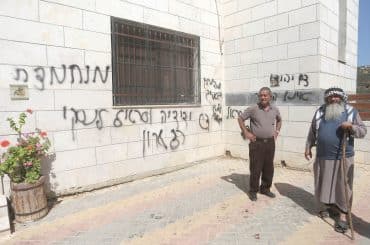 Palestinians inspect a burned-out mosque in the village of Aqraba, south of Nablus in the West Bank, after Israeli settlers set fire to the entrance and spray-painted Hebrew graffiti on the walls. (Photo: Mohammed Nasser/APA Images)