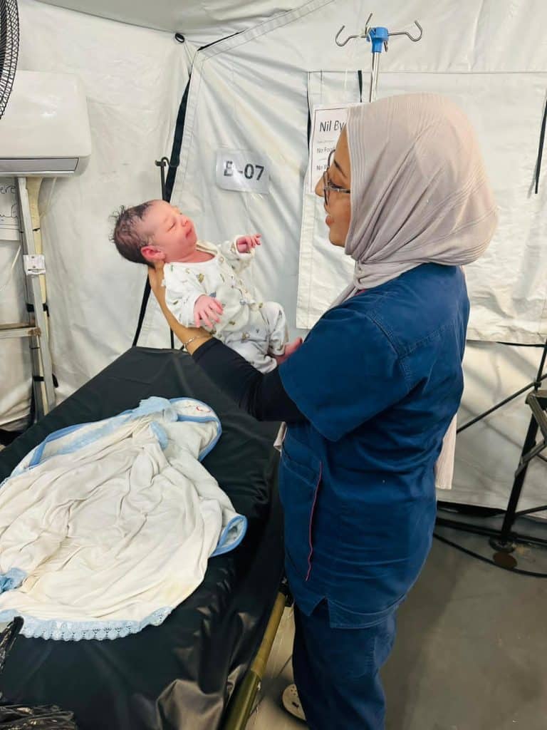 Renad Salem with a newborn after a successful delivery at the UK-Med field hospital in al-Mawasi, Khan Younis (Photo Courtesy of Renad Salem)