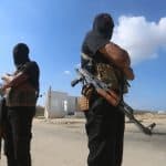Members of the armed wing of Hamas, the al-Qassam Brigades, stand guard during the handover of Israeli captives to the Red Cross as part of the first phase of the ceasefire between Israel and Hamas, October 13, 2025. (Photo: Omar Ashtawy/APA Images)