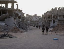 Palestinians walk amid the rubble of destroyed buildings in Khan Younis, October 21, 2025. (Photo: Omar Ashtawy/APA Images)