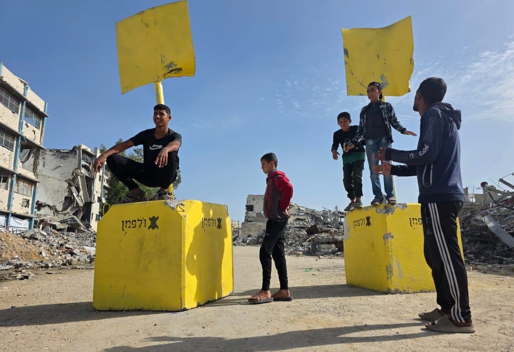 Displaced Palestinian families sheltering inside the UNRWA-run Malak School in Bani Suheila, east of Khan Younis, find themselves suddenly located within the newly designated "yellow line" after the Israeli army repositioned the yellow concrete blocks used to demarcate the so-called "temporary withdrawal line" inside Gaza, December 9, 2025. (Photo: Tariq Mohammad/APA Images)