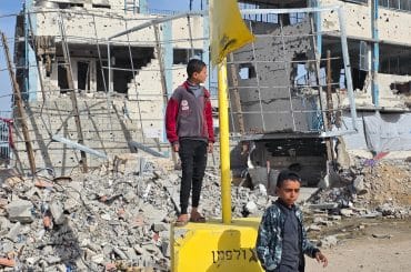 Displaced Palestinian families sheltering inside the UNRWA-run Malak School in Bani Suheila, east of Khan Younis, find themselves suddenly located within the newly designated "yellow line" after the Israeli army repositioned the yellow concrete blocks used to demarcate the so-called "temporary withdrawal line" inside Gaza, December 9, 2025. (Photo: Tariq Mohammad/APA Images)