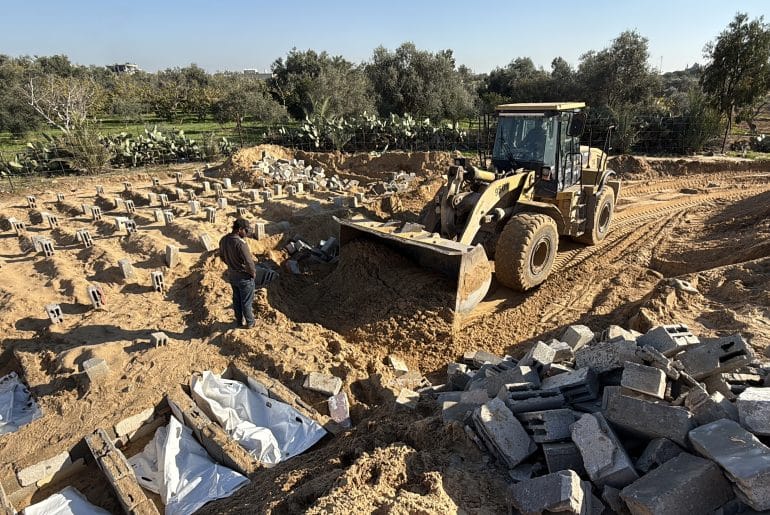 Palestinian crews in Gaza dig mass graves amidst a campaign to recover the remains of bodies that have been trapped under the rubble of buildings since the start of the genocide. December 2025. (Anas Ahmed/Mondoweiss)