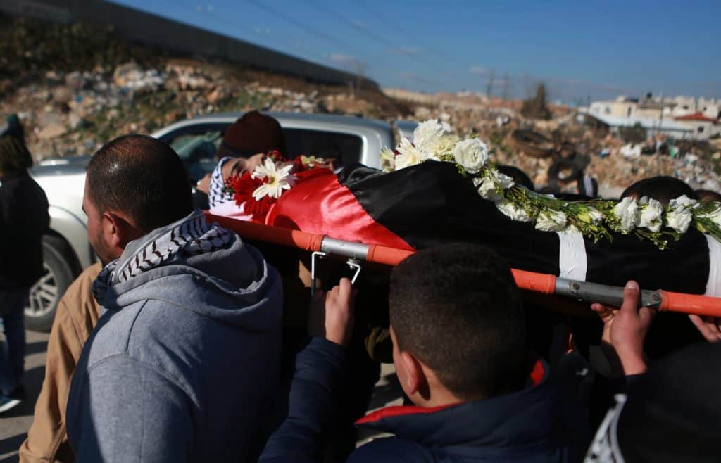 Los dolientes portan el cuerpo de Mohammad Zeidan, de 16 años, un joven palestino de la ciudad cisjordana de Bir Nabala, a las afueras de Jerusalén, quien fue asesinado por las fuerzas de seguridad israelíes el 25 de noviembre de 2017, tras presuntamente intentar un apuñalamiento. Su cuerpo fue devuelto por las autoridades israelíes meses después, el 2 de febrero de 2017. (Foto: Shadi Hatem/APA Images)