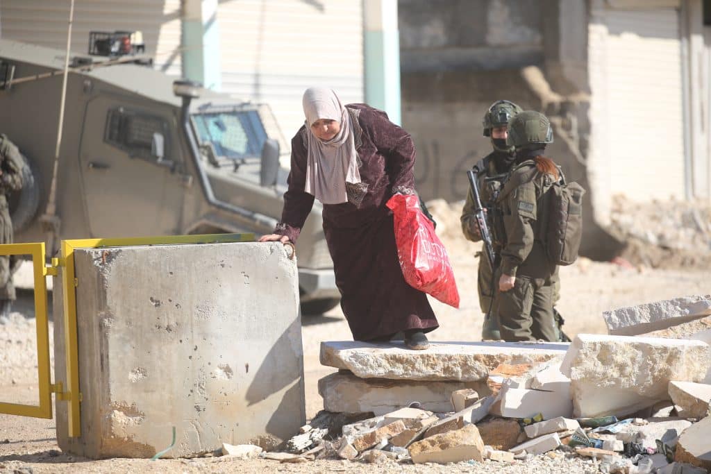 Palestinians carry their belongings after being forced to leave their homes by Israeli forces during a raid on the Nur Shams refugee camp in Tulkarem, December 17, 2025. (Photo: Mohammed Nasser/APA Images)
