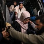 Palestinians de-board a bus after crossing the Rafah crossing into Gaza.