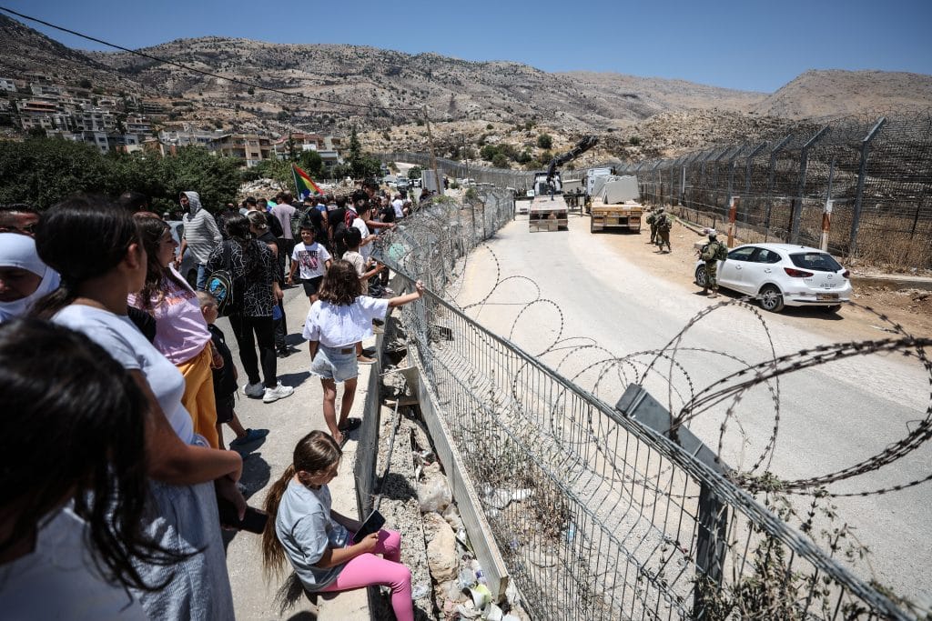 Syrian Druze return to Syria through the Israeli-Syrian border gate under the watch of Israeli soldiers, as part of a rare cross-border movement near the town of Majdal Shams in the Israeli-occupied Golan Heights, Thursday, July 17, 2025. (Photo: Saeed Qaq/ZUMA Press Wire\ APA Images)
