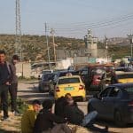 Palestinians wait at an Israeli military checkpoint near Nablus after Israeli forces close checkpoints and iron gates at the entrances of Palestinian cities during the ongoing U.S.-Israeli war on Iran, March 3, 2026. (Photo: Mohammed Nasser/APA Images)