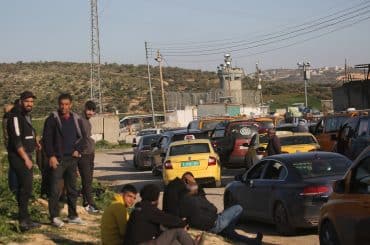 Palestinians wait at an Israeli military checkpoint near Nablus after Israeli forces close checkpoints and iron gates at the entrances of Palestinian cities during the ongoing U.S.-Israeli war on Iran, March 3, 2026. (Photo: Mohammed Nasser/APA Images)