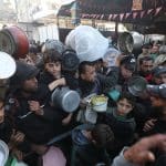 Displaced Palestinian families attempt to secure food from a charity kitchen in Nuseirat refugee camp amid food shortages after Israel restricted aid entry to Gaza following its war on Iran, March 3, 2026. (Photo: Moiz Salhi/APA Images)