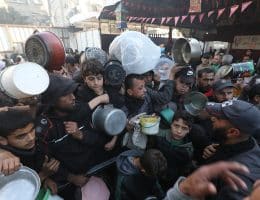 Displaced Palestinian families attempt to secure food from a charity kitchen in Nuseirat refugee camp amid food shortages after Israel restricted aid entry to Gaza following its war on Iran, March 3, 2026. (Photo: Moiz Salhi/APA Images)