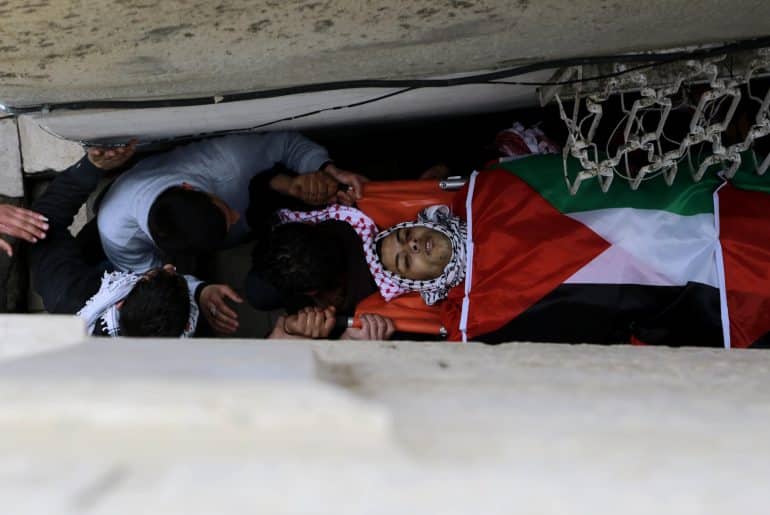 Palestinian mourners carry the body of 19-year old Jihad al-Jaafari, who was shot dead on the roof of his house after Israeli soldiers raided Dheisheh refugee camp at dawn in Bethlehem, February 24, 2015. (Photo: Shadi Hatem/APA Images)