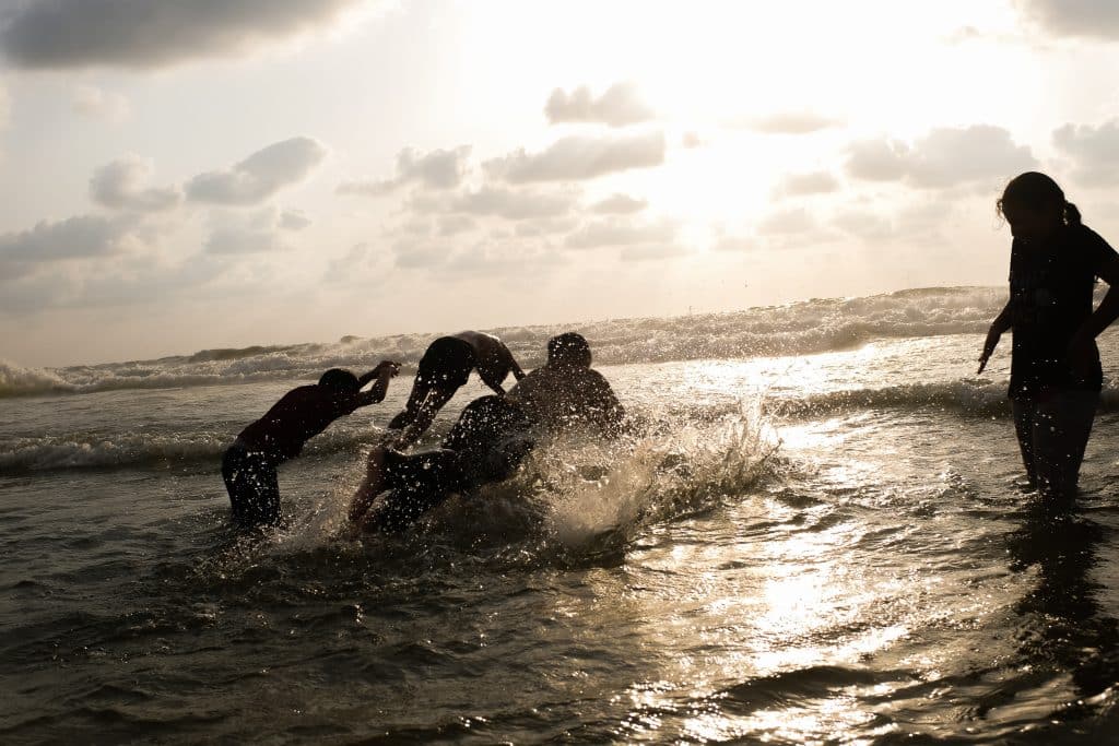 Boys run through the surf, playing together along Gaza’s shoreline, August 16, 2023. (Photo: Mahmoud Nasser)