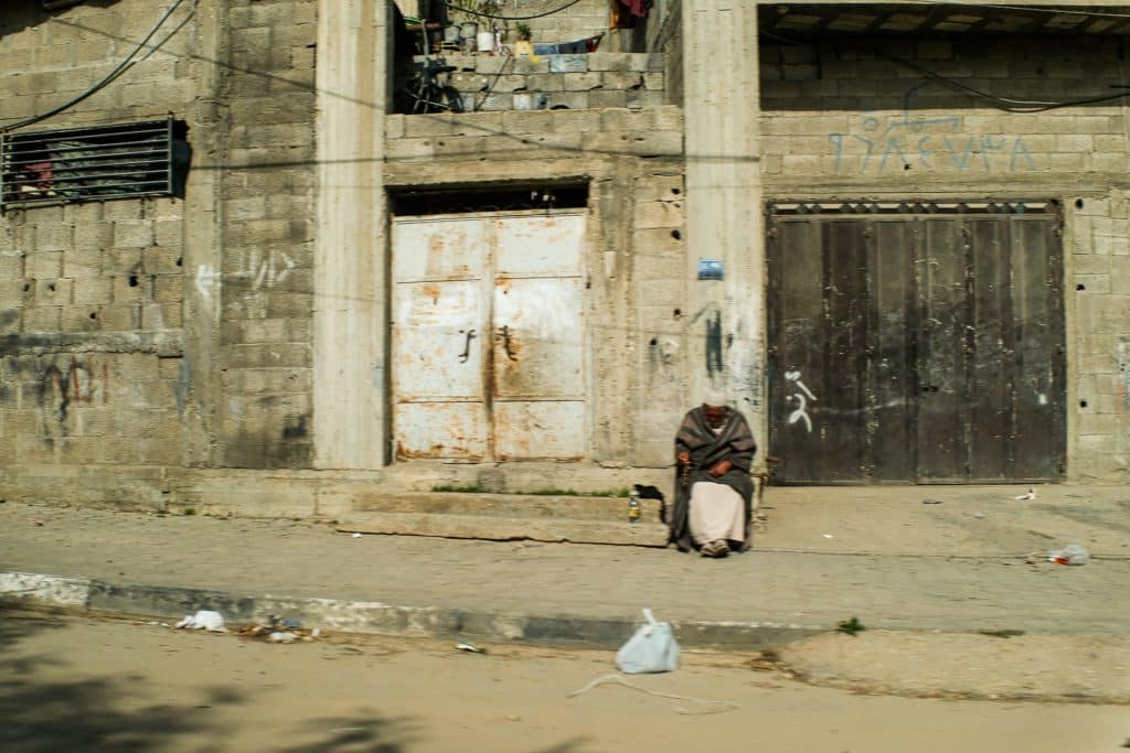 A man sits alone along a quiet street, resting outside of his house, February 17, 2022. (Photo: Mahmoud Nasser)