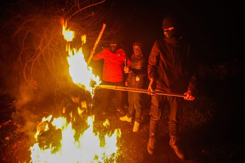 Masked Palestinians on guard duty during the night to fend off attacks by Israeli settlers, south of Nablus March 1, 2023. (Photo: Nasser Ishtayeh/SOPA Images via ZUMA Press Wire/APA Images)