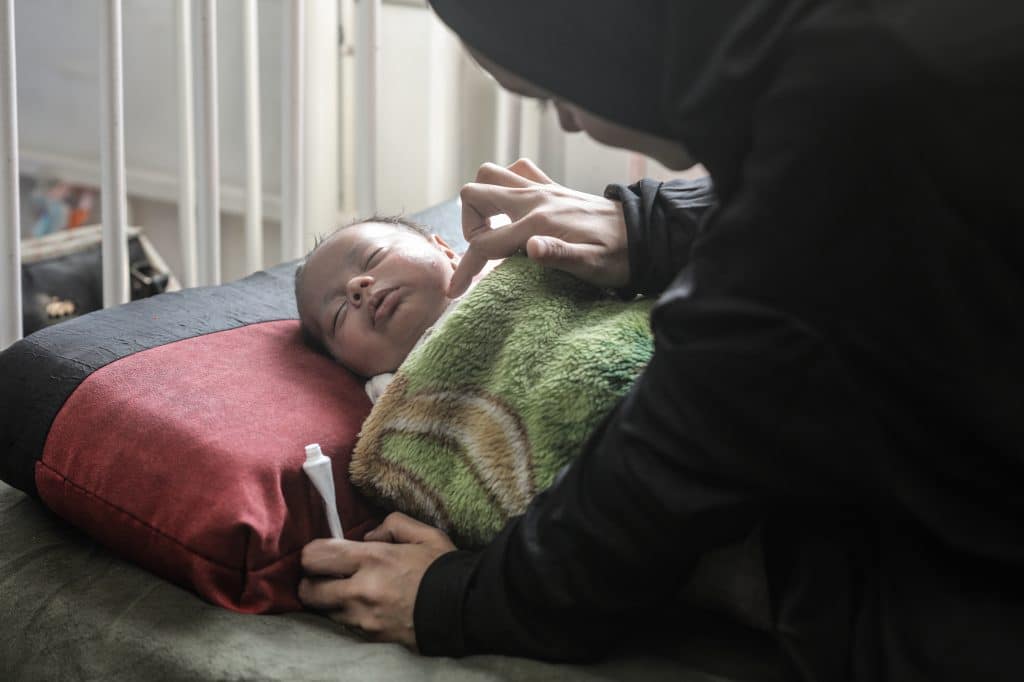 Yasmeen al-Jamala cares for her newborn son, Adam al-Ustaz, who receives treatment at al-Rantisi Children's Hospital in Gaza City after being bitten by a rat inside a displacement tent, March 28, 2026. (Photo: Moiz Salhi/APA Images)