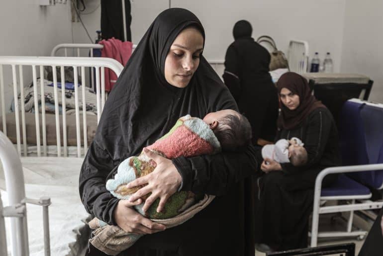 Yasmeen al-Jamala holds her newborn son, Adam al-Ustaz, who receives treatment at al-Rantisi Children's Hospital in Gaza City after being bitten by a rat inside a displacement tent, March 28, 2026. (Photo: Moiz Salhi/APA Images)