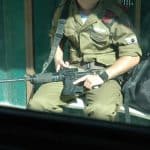 An off-duty Israeli soldier at a bus stop in Jerusalem, August 17, 2004. (Photo: Wikimedia Commons/Justin McIntosh)