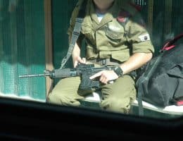 An off-duty Israeli soldier at a bus stop in Jerusalem, August 17, 2004. (Photo: Wikimedia Commons/Justin McIntosh)