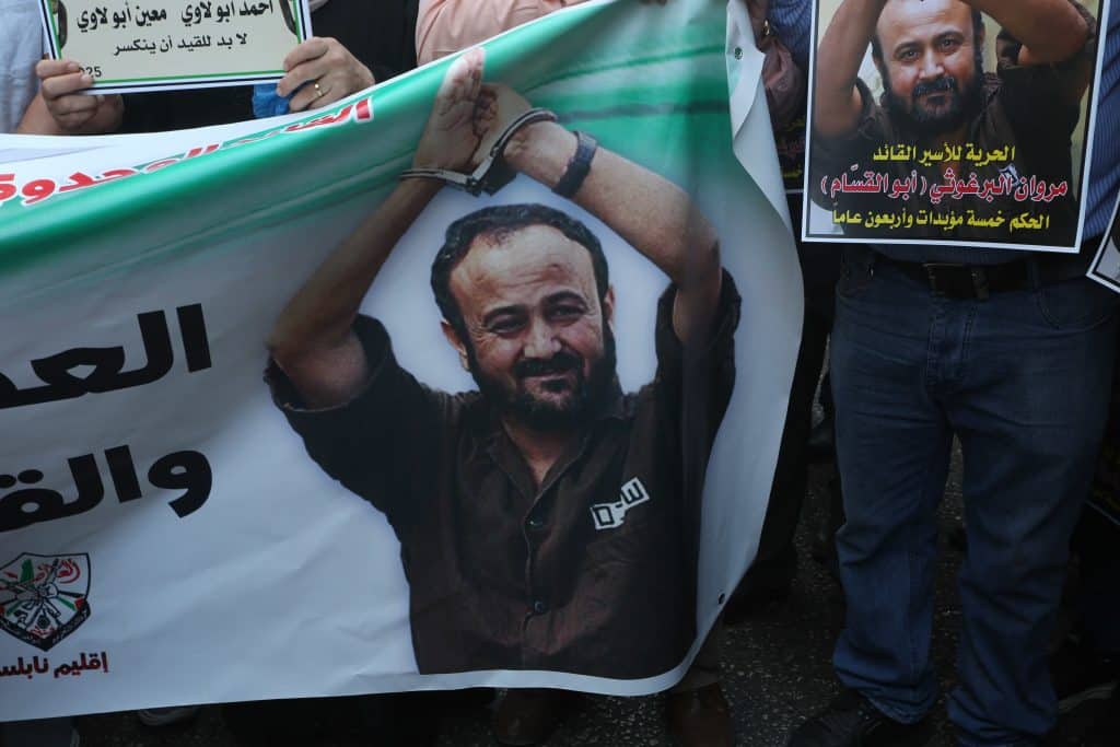 Palestinian protesters hold flags and placards of Fatah leader Marwan Barghouti during a solidarity march in Nablus, August 20, 2025. (Photo: Mohammed Nasser/APA Images)