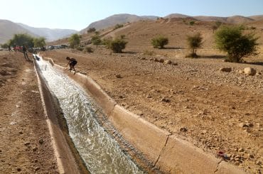 Palestinians swim in al-Auja spring's water in July 2022. (Photo: Wajed Nobani/APA Images)