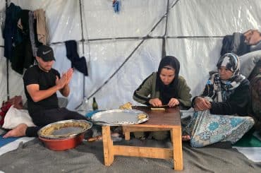 A displaced Palestinian family prepares traditional Eid cookies in their tent in Khan Younis, south Gaza, May 26, 2026. (Photo: Tariq Mohammad/APA Images)
