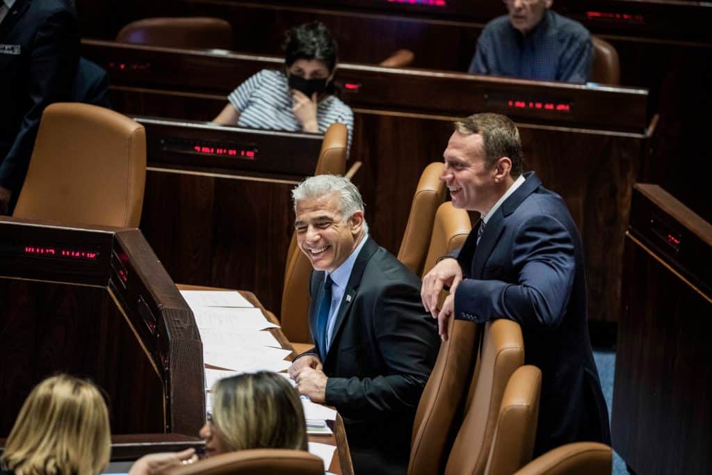 Yair Lapid (L) at a session of the Knesset ahead of a vote to dissolve the government, June 30, 2022. (Photo: Ilia Yefimovich/dpa via ZUMA Press/APA Images)