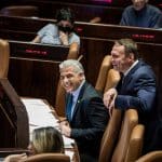 Yair Lapid (L) at a session of the Knesset ahead of a vote to dissolve the government, June 30, 2022. (Photo: Ilia Yefimovich/dpa via ZUMA Press/APA Images)