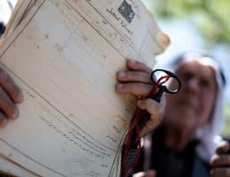A Palestinian man shows deeds to his land during a rally marking the Nakba in Gaza City, on May 15, 2013. (Photo: Ali Jadallah / APA Images)