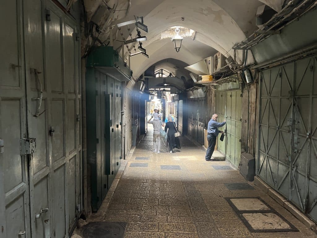 Palestinian shop owner closes up his store in Jerusalem's Old City before the Flag March arrives, on May 15, 2026. (Photo: Jared Hillel/Mondoweiss)