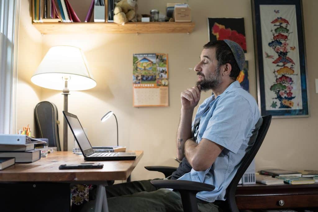 Michael Margolin a Rabbi in training and spiritual leader at Tikkun v'Or Reform Temple writes his Yom Kippur sermon on Sep. 26, 2025, at his home in Ithaca, NY. (Photo: Caleb Kaufman)