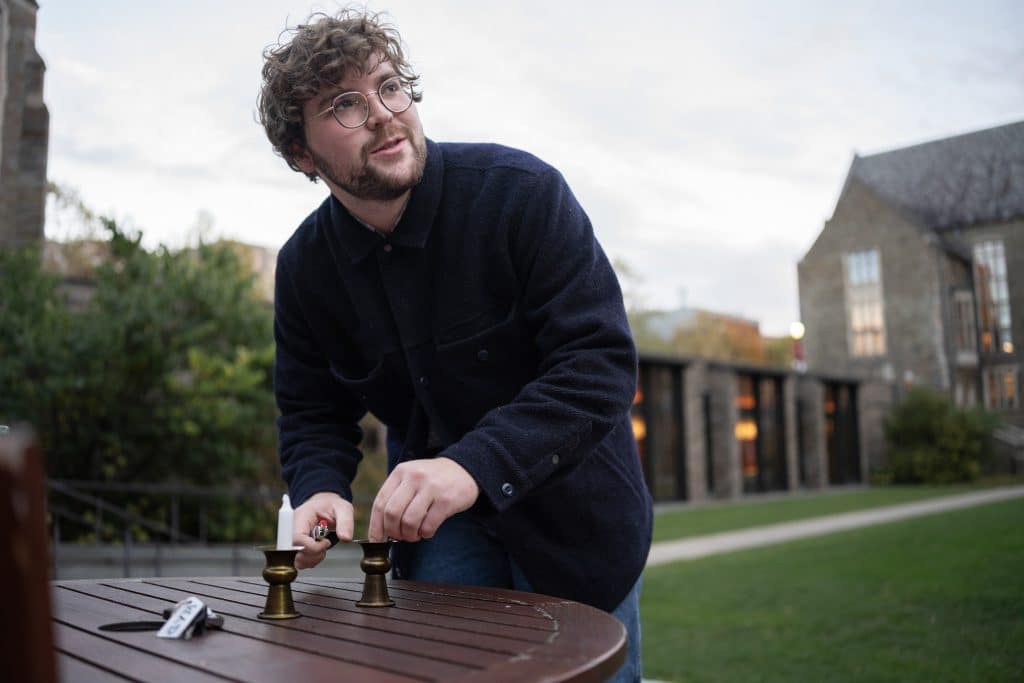 Jacob Berman sets up the candles for a Chavurah Shabbat service on Oct. 17, 2025, at Cornell University, in Ithaca, NY (Photo: Caleb Kaufman) 