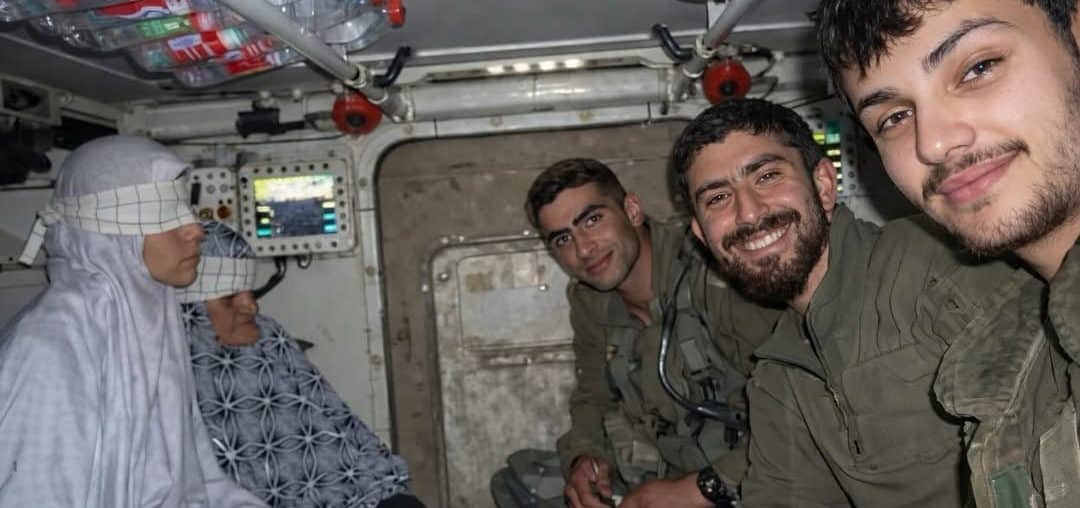 Israeli soldiers take a selfie with two detained Palestinians from Gaza, Aisha al-Aqqad, 78, and her daughter Huda, 41, during the Israeli ground invasion of Khan Younis in December 2023. The photo recently surfaced on social media. (Photo: Social Media)