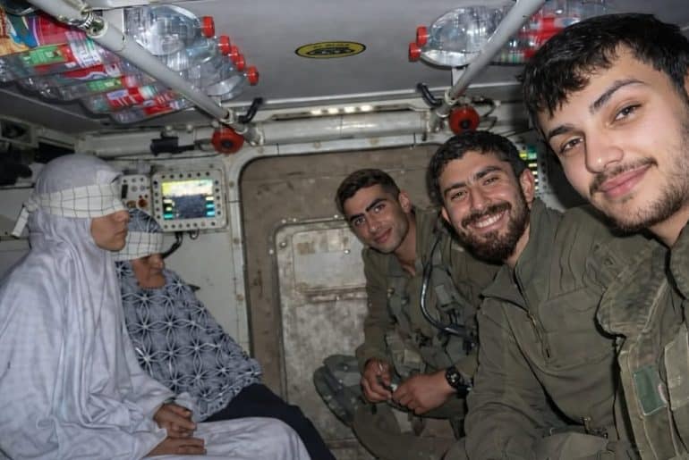 Israeli soldiers take a selfie with two detained Palestinians from Gaza, Aisha al-Aqqad, 78, and her daughter Huda, 41, during the Israeli ground invasion of Khan Younis in December 2023. The photo recently surfaced on social media. (Photo: Social Media)