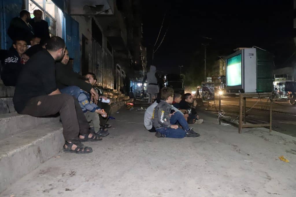 Palestinians in Gaza watch a football match in the street on a home TV during the 2022 FIFA World cup in Qatar, Gaza City, November 29, 2022. (Photo: Youssef Abu Watfa/APA Images)