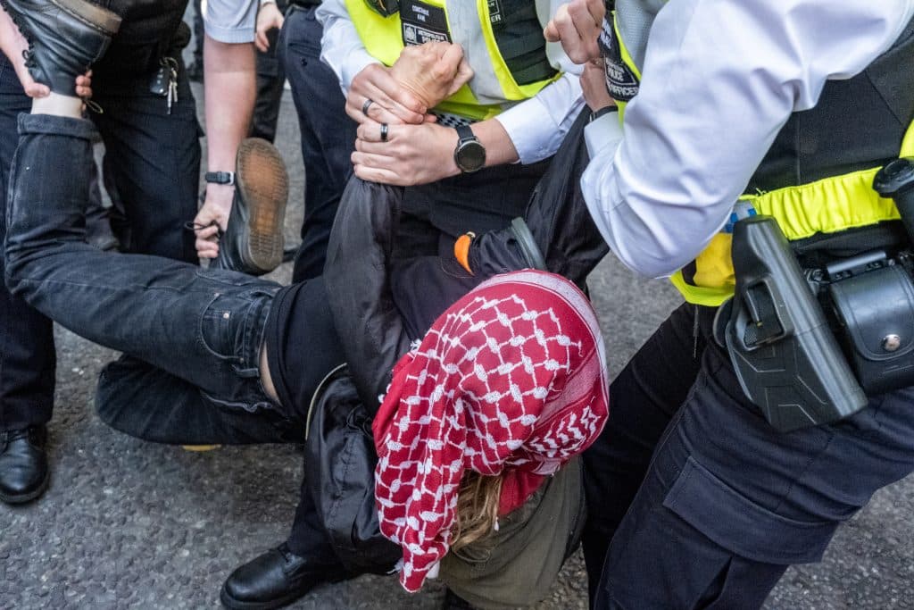 A protester is twisted as they are carried away by police officers. (Photo: Aidan Frere-Smith)