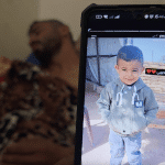 Bahaha Abu al-Ajeen at al-Aqsa Martyrs Hospital with a photo of his son, Rayyan. (Photo: Screenshot from video testimony gathered by Osama Kahlout for Mondoweiss)