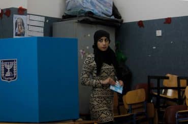 A Palestinian woman and citizen of Israel prepares to cast her ballot at a polling station in the Palestinian town of Umm al-Fahm on March 17, 2015. (Photo by Muammar Awad/apa images)