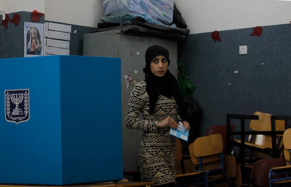 A Palestinian woman and citizen of Israel prepares to cast her ballot at a polling station in the Palestinian town of Umm al-Fahm on March 17, 2015. (Photo by Muammar Awad/apa images)