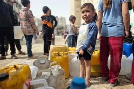 Palestinians in Khan Yunis collect water from tanker trucks and carry it in jerrycans to their homes amid continued water shortages in Gaza, April 18, 2026. (Photo: Tariq Mohammad/APA Images)