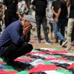 Palestinians attend the funeral of 112 members of the Hassayna and Abu Sharia clans, who were killed in an Israeli strike in November 2023 during the beginning of the Gaza genocide. They were laid to rest on August 4, 2026, after their remains were recovered from underneath the rubble, nearly three years later. (Photo: Bilal Osama/APA Images)