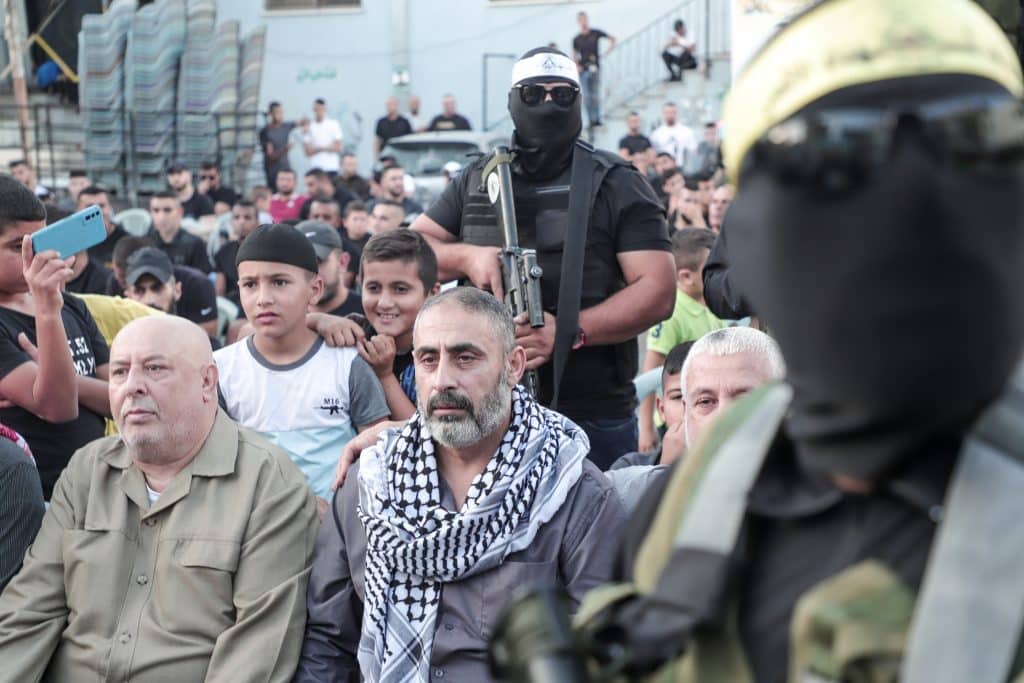 Fathi Khazem flanked by Jenin resistance fighters while speaking at a rally marking the 35th anniversary of the founding of the Islamic Jihad movement, Jenin, October 6, 2022. (Photo: APA Images)