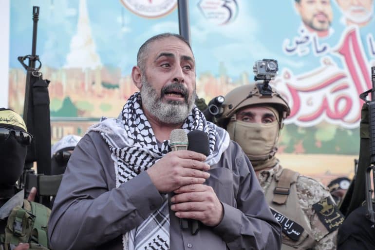 Fathi Khazem flanked by Jenin resistance fighters while speaking at a rally marking the 35th anniversary of the founding of the Islamic Jihad movement, Jenin, October 6, 2022. (Photo: APA Images)
