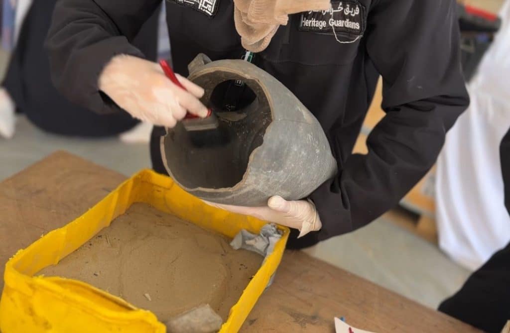 Members of the Heritage Guardians volunteer team, affiliated with the Mayasem Association for Culture and the Arts, examine and document historical artifacts recovered from beneath the rubble in Gaza, Khan Younis, June 9, 2026. (Photo: Youssef Abu Watfa/APA Images)